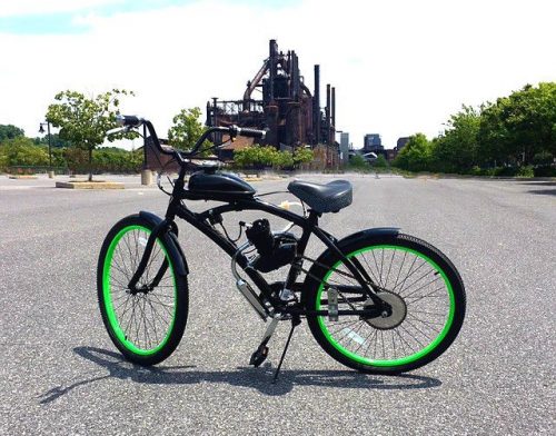 A bicycle with green wheels parked in the street.