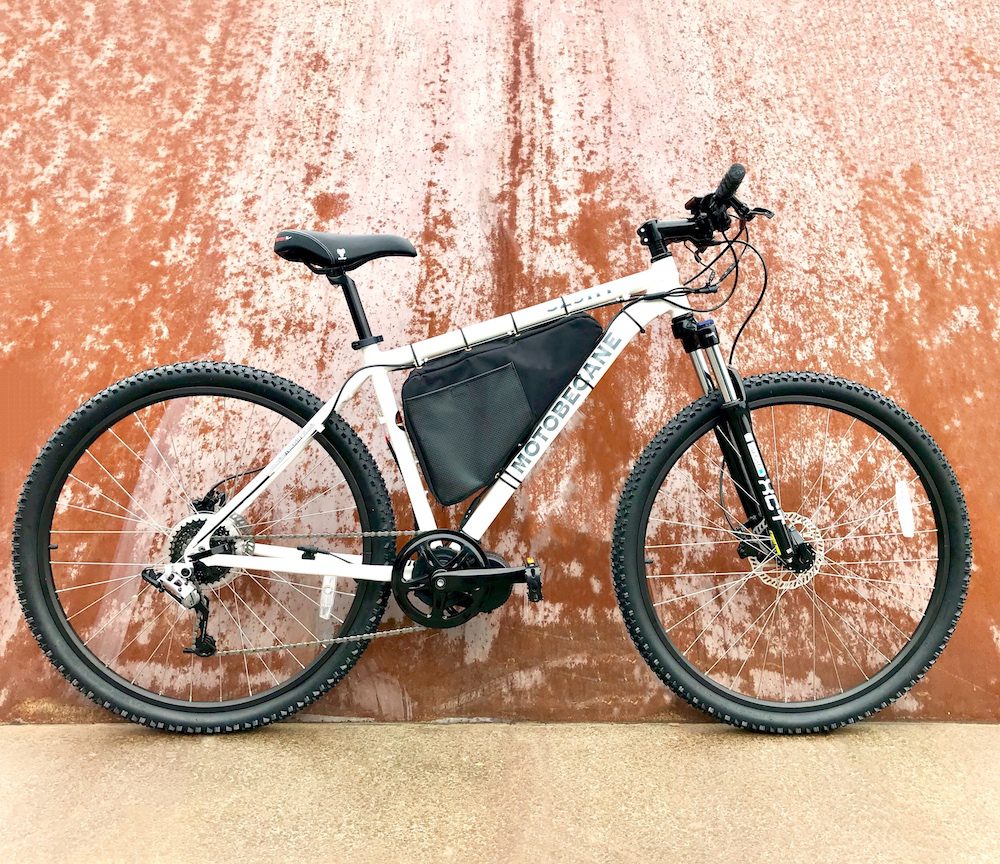 A bicycle leaning against the wall of an orange building.