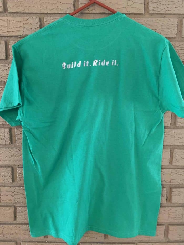 A green shirt that says build it, ride it.