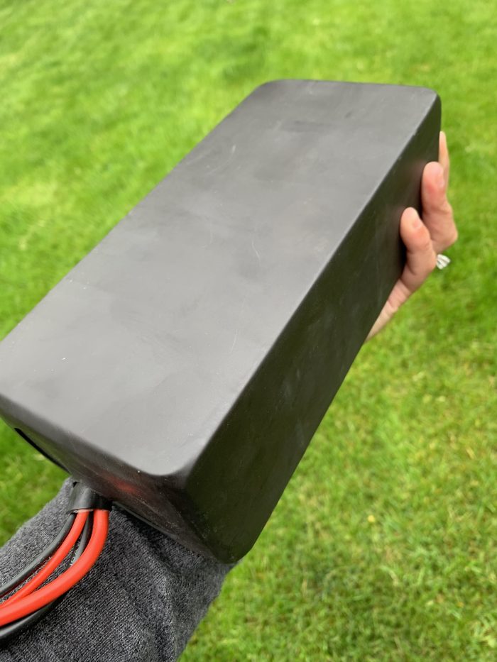 A person holding a black box in their hand.