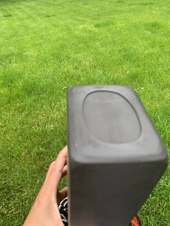 A person holding onto a box in the grass