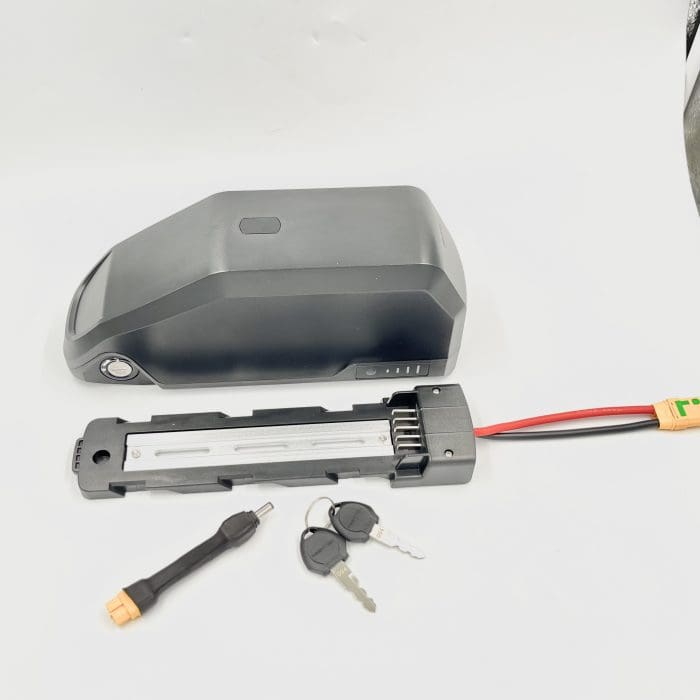 A battery and keys are laying on the table.